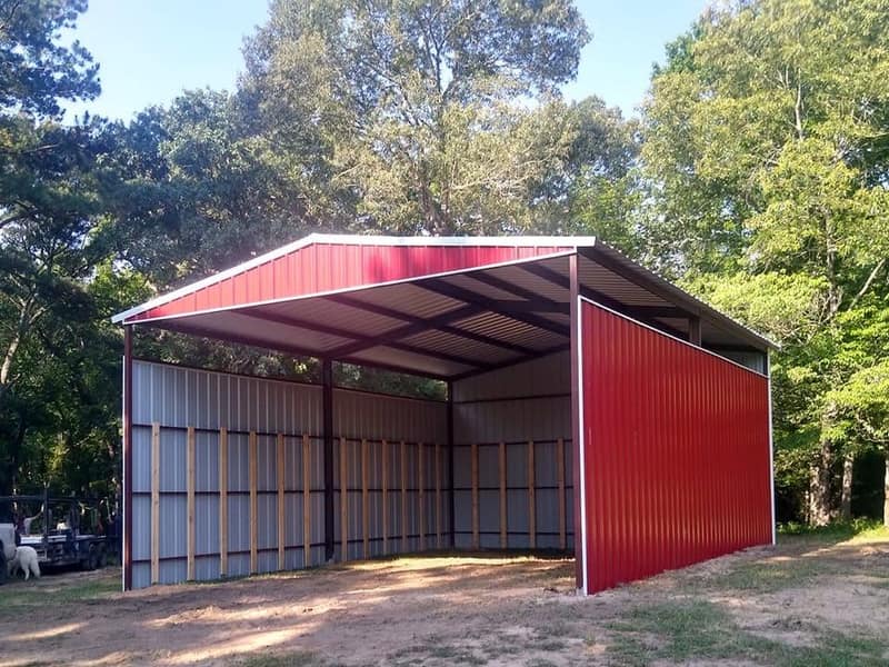 Red open-front metal loafing shed with white trim, back and side walls closed in