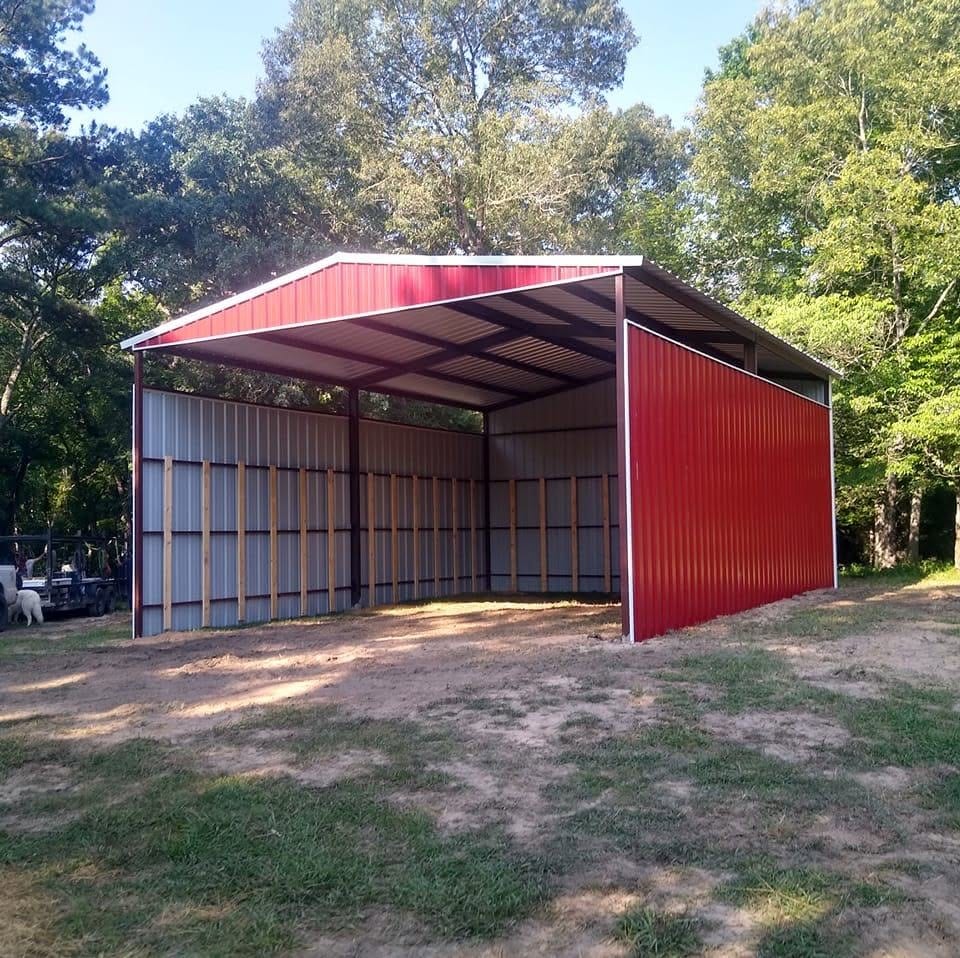 Red metal carport with enclosed side under tall trees