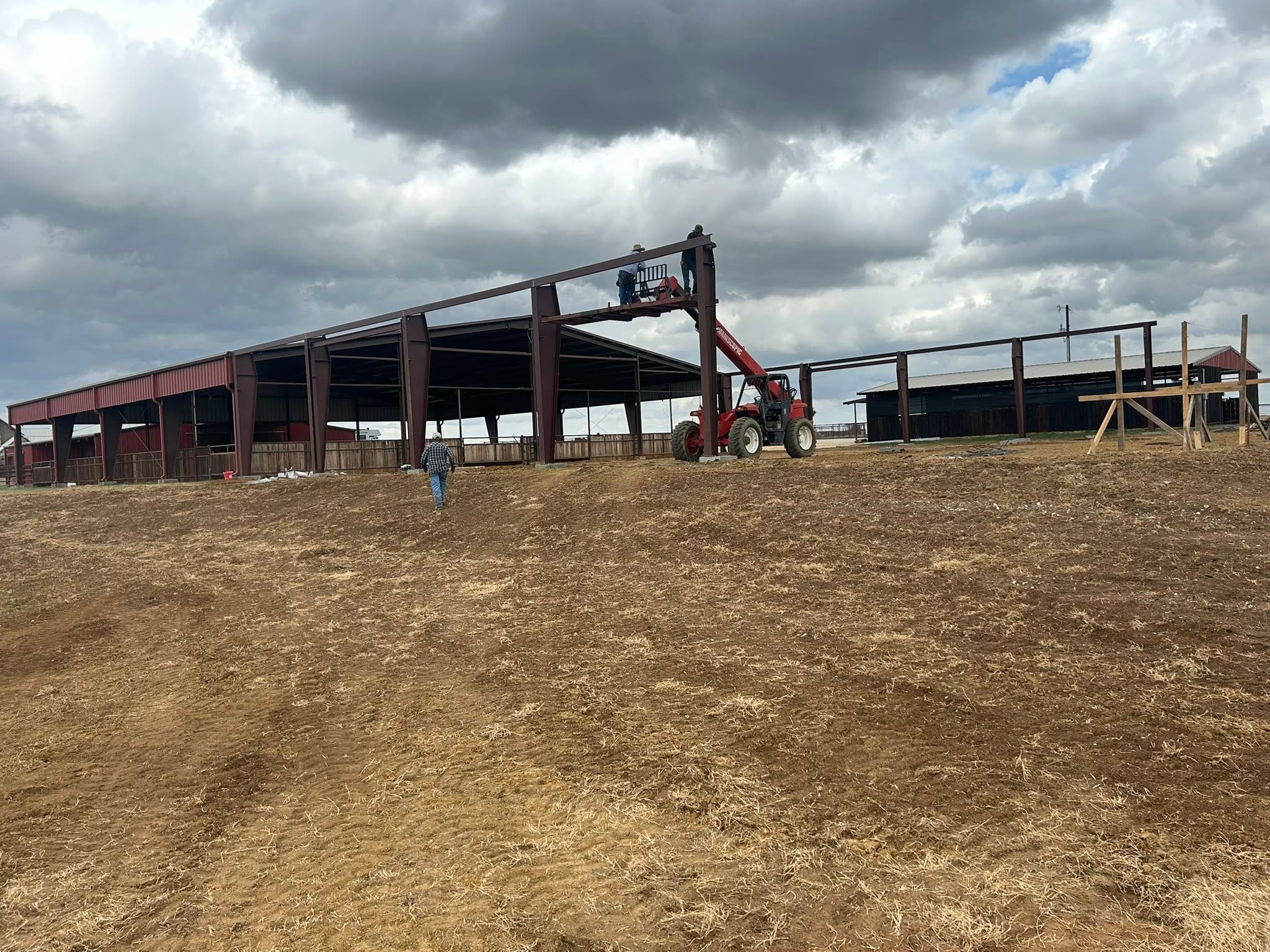 Steel frame of a metal building going up with a telehandler on site