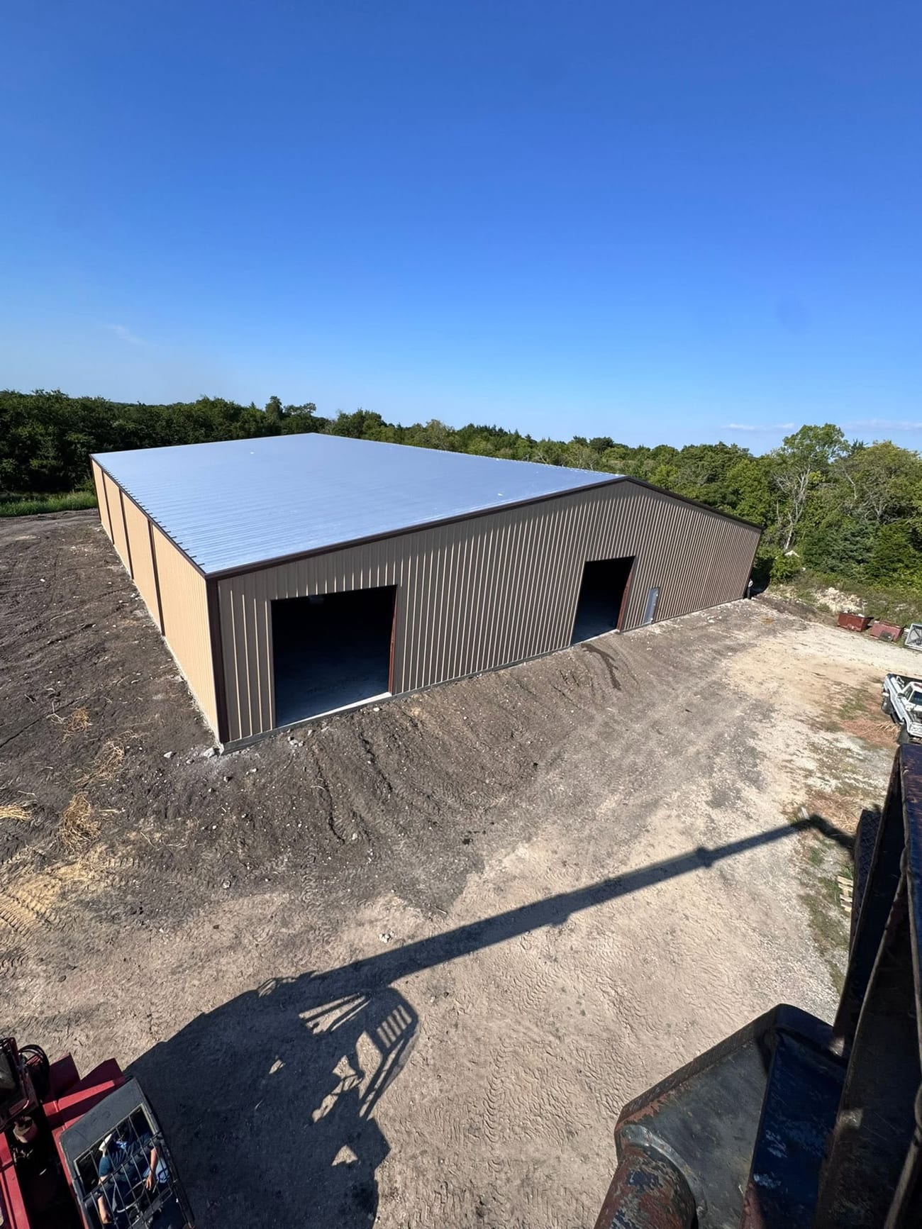 Tan metal shop with a silver roof seen from above