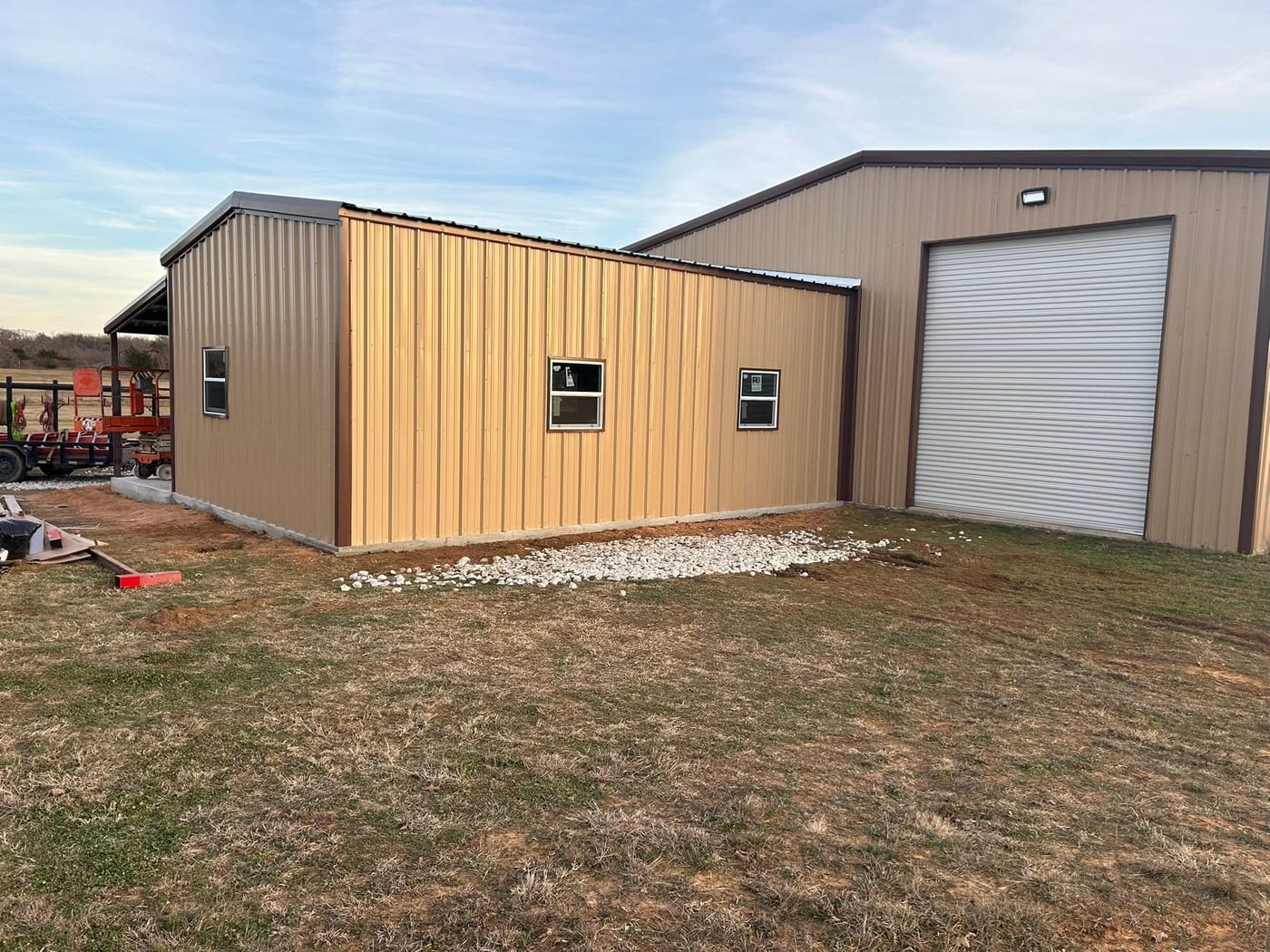 Tan metal workshop with a white roll-up door